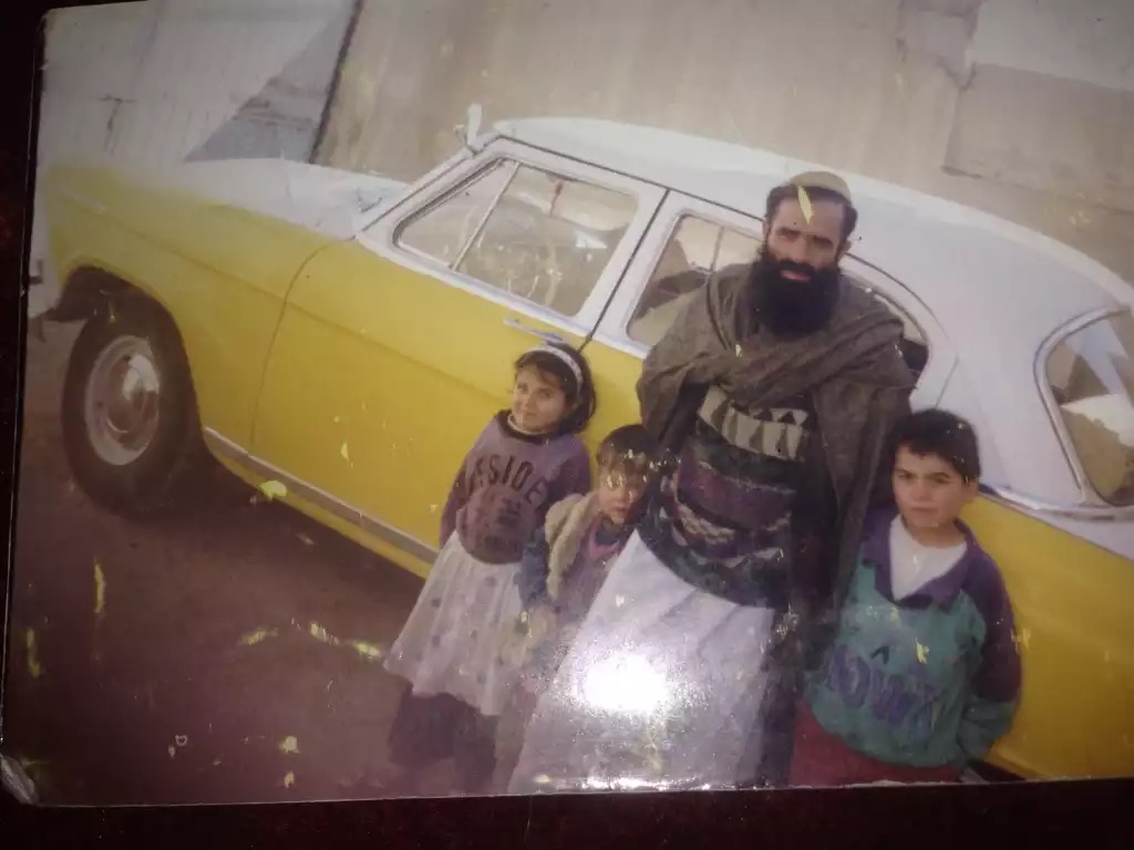 Jason Essazay as a child with his father and siblings in Afghanistan